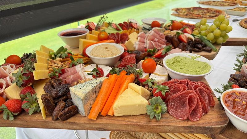 A grazing table of cheese, charcuterie and fresh produce