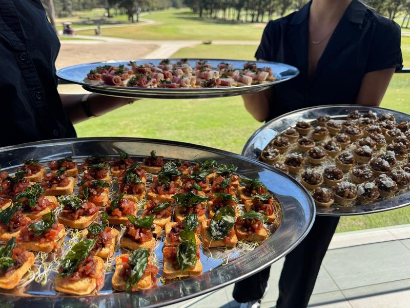 Waiter serving canapés on the greens