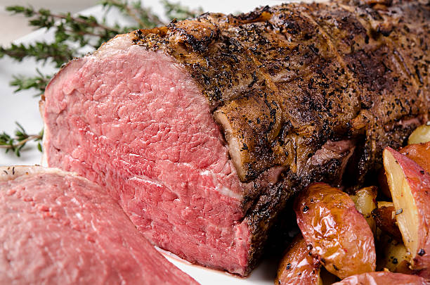 Sliced roast beef with roasted potatoes and thyme