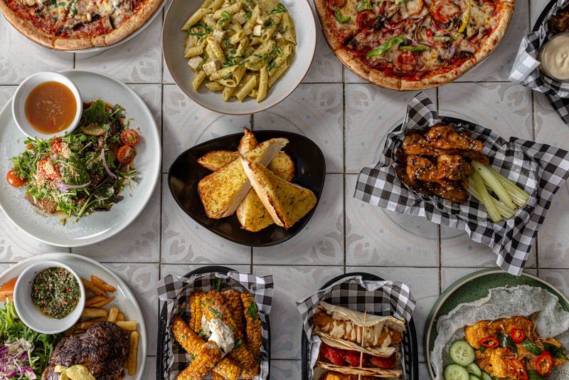 A spread of pizzas, pasta, wings, ribs and sides