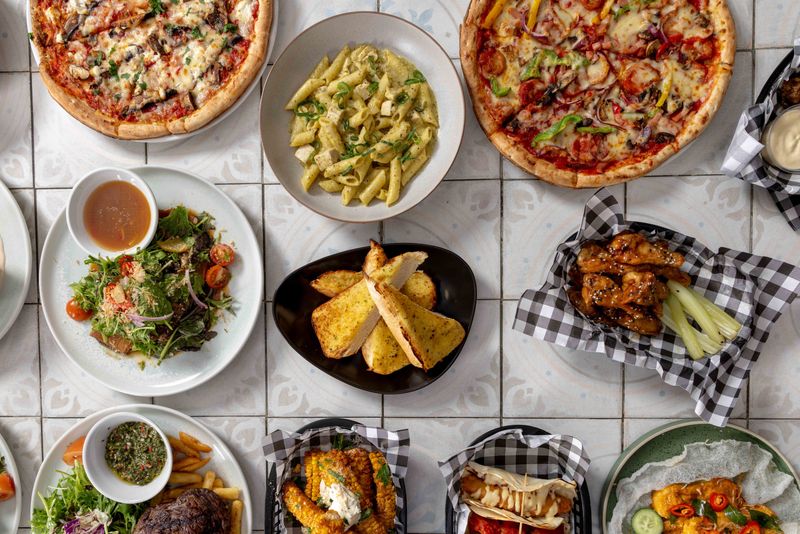 A spread of pizzas, pasta, steak and sides