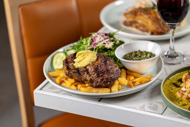 Char-grilled steak with chimichurri, chips and salad at The Fairway