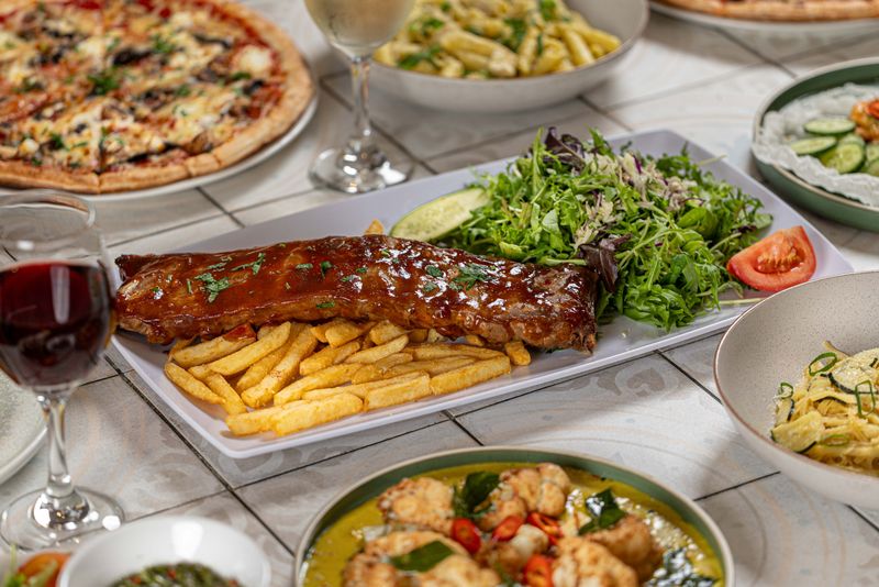 BBQ ribs, pizza and pasta on the table